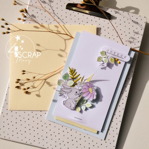 Carte de scrapbooking sur le thème de paques avec un petit lapin de paques, des fleurs de printemps...